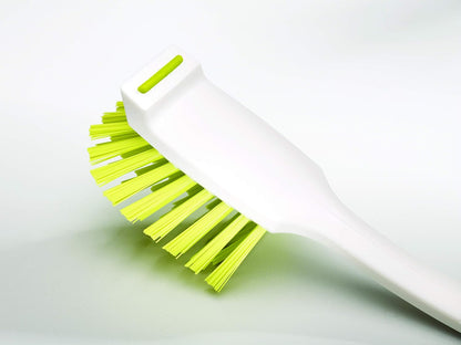 curved brush head designed to reach corners of trays and pans